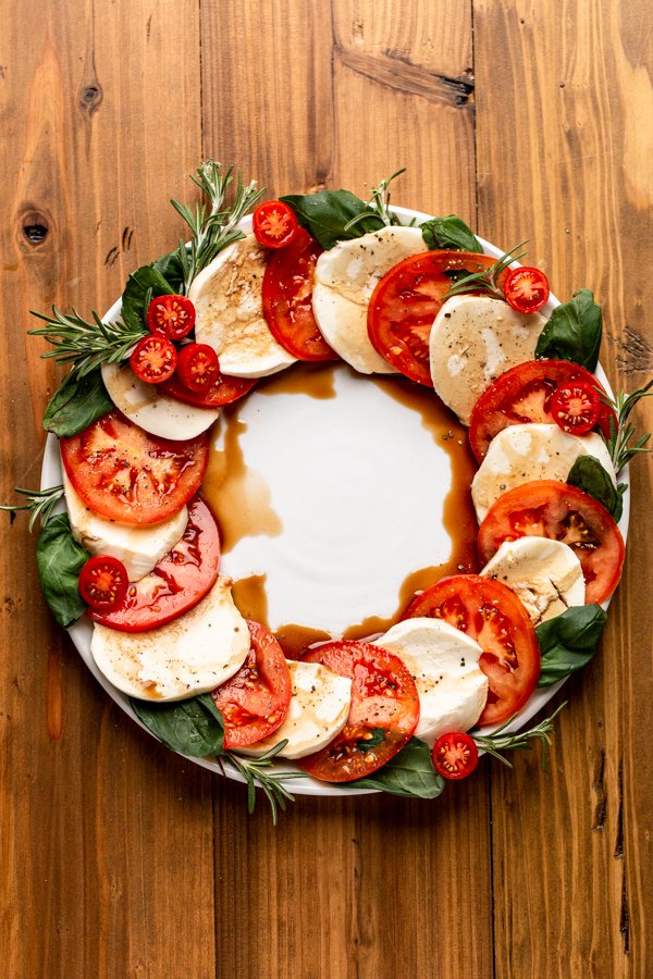 Caprese salad made into a wreath shape on a white plate