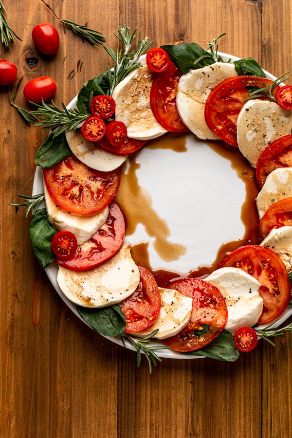 Caprese salad made into a wreath shape on a white plate