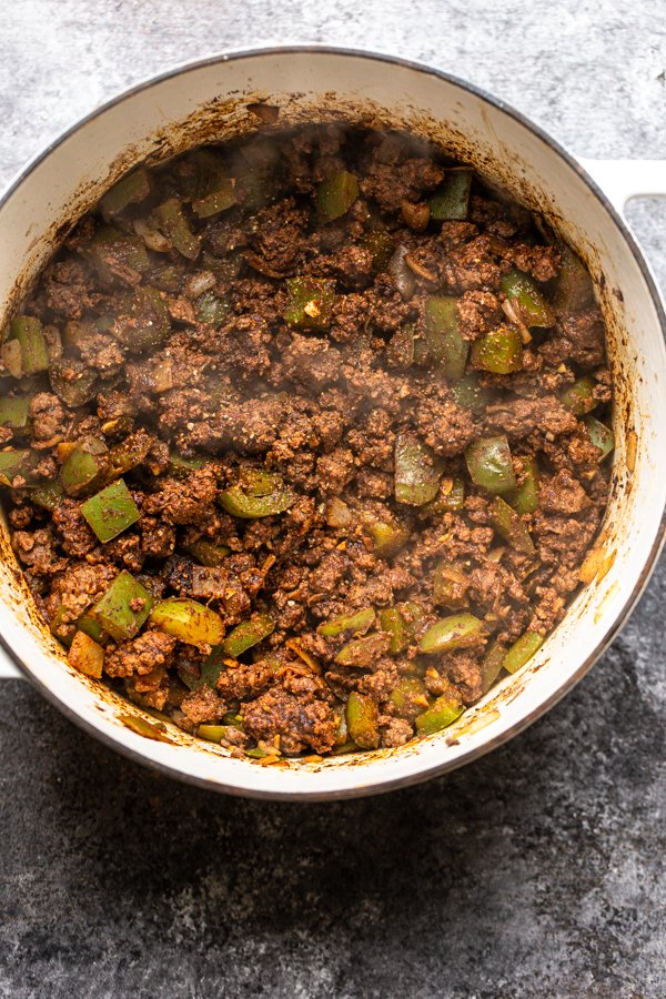 onions, peppers and ground meat cooking in a pot