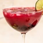 blackberry mockarita in a coupe glass with a lime wedge