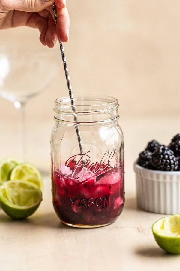 mixing a blackberry drink in a mason jar