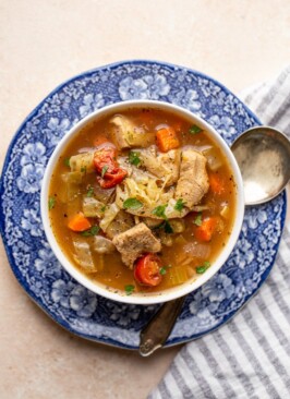 chicken and vegetable soup on a blue and white plate