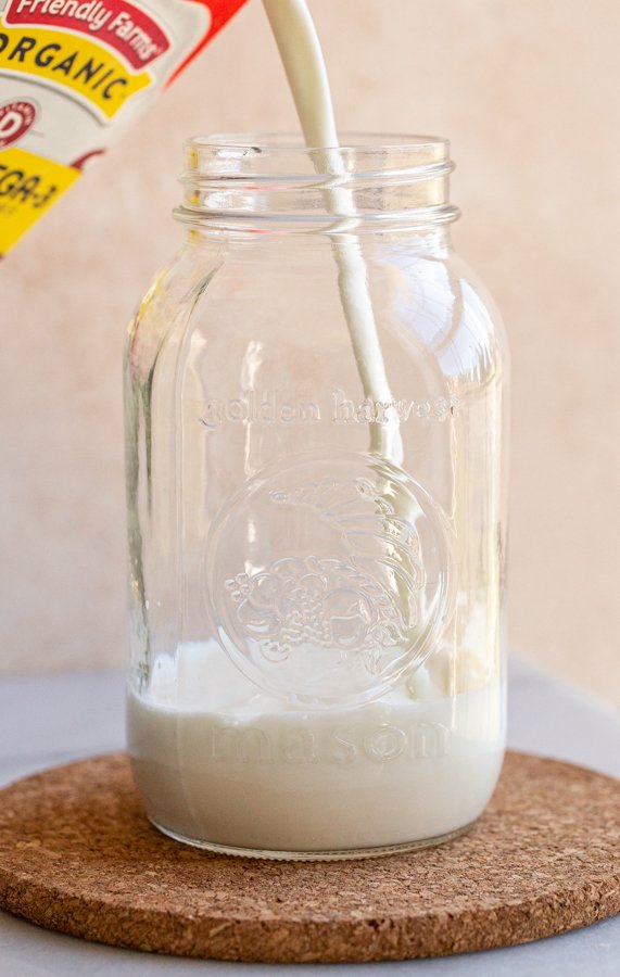 pouring milk in a glass jar