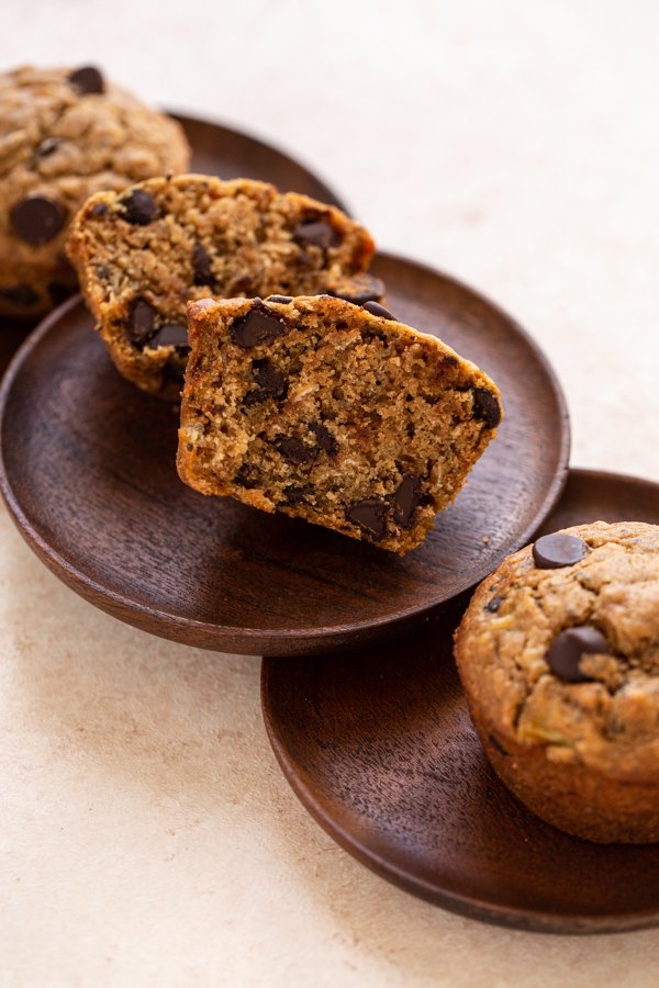 sourdough banana bread muffins cut in half on small wood plates