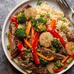 venison stir fry on a light blue plate with a fork