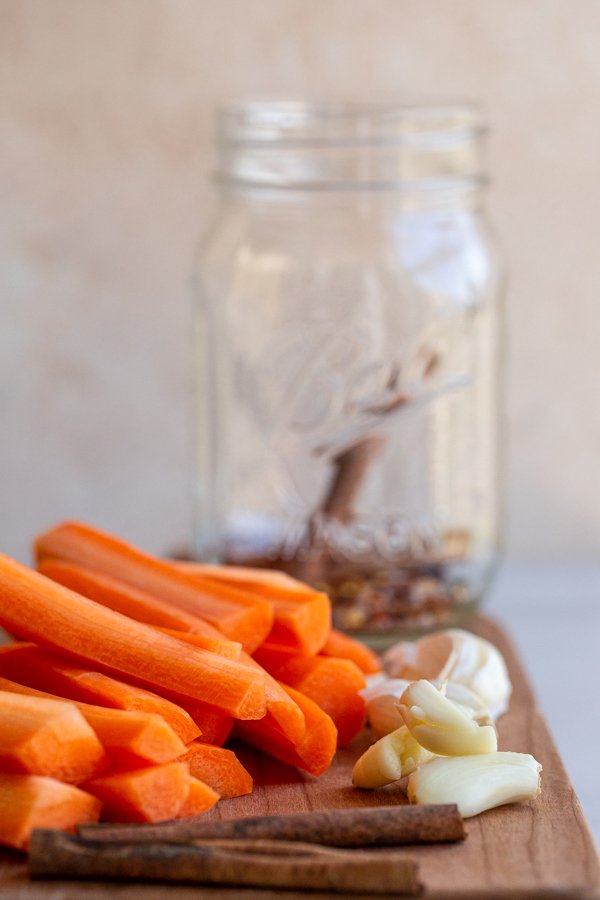 cut carrot sticks and garlic with a glass jar in the background