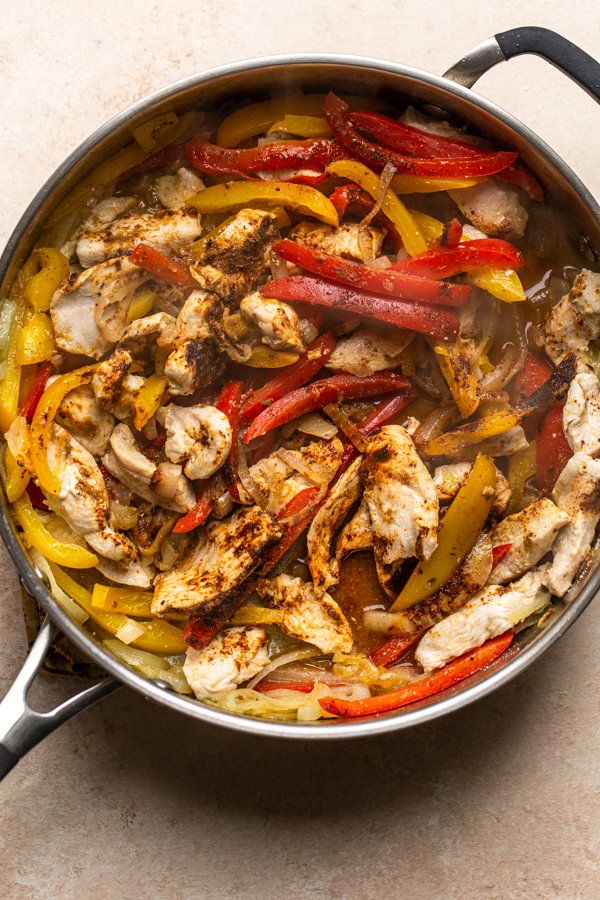 chicken, peppers and onions in a skillet