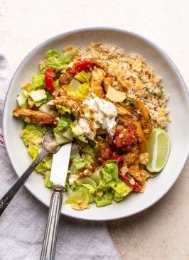 chicken fajita bowl with sour cream in a white bowl