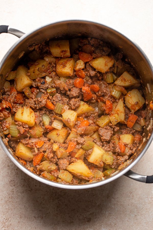 meat, potatoes and veggies cooking in a pot