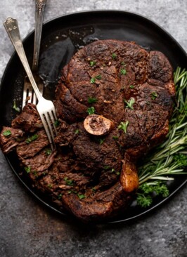 bear roast being torn apart with forks on a black serving platter