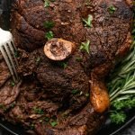 bear roast being torn apart with forks on a black serving platter