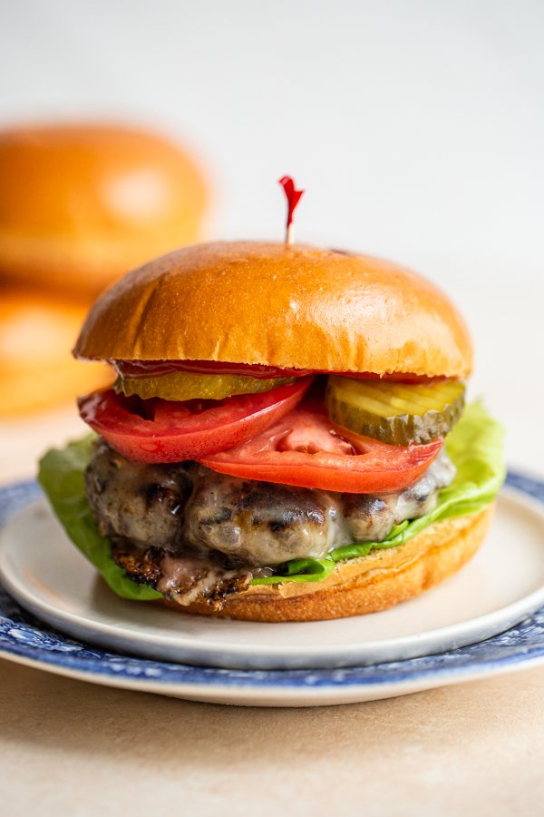 bear meat burger on 2 plates with a toothpick in it