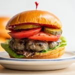 bear meat burger on 2 plates with a toothpick in it