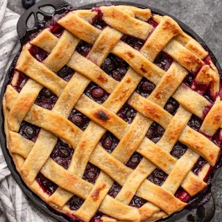 blueberry pie on a grey counter in a black pie dish