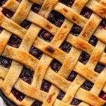 blueberry pie on a grey counter in a black pie dish