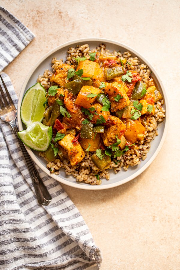 mango chicken curry on a plate with limes