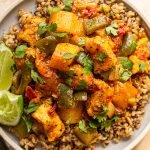 mango chicken curry on a plate with limes