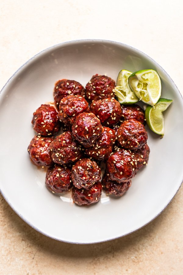 smoked venison meatballs in a white bowl with lime slices