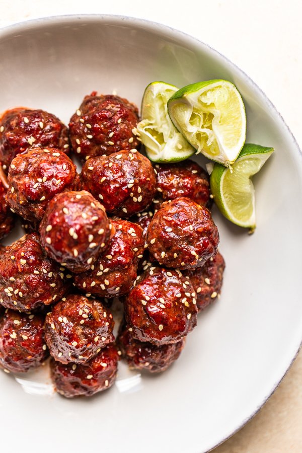 smoked venison meatballs in a white bowl with lime slices