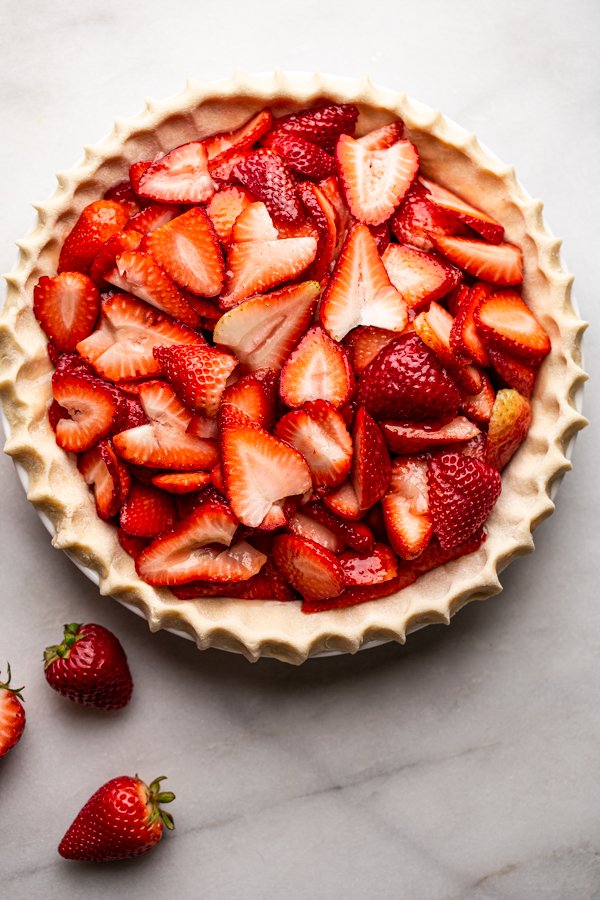 sliced strawberries in a pie dish, unbaked