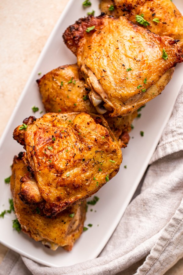 traeger grilled chicken thighs on a white rectangular plate