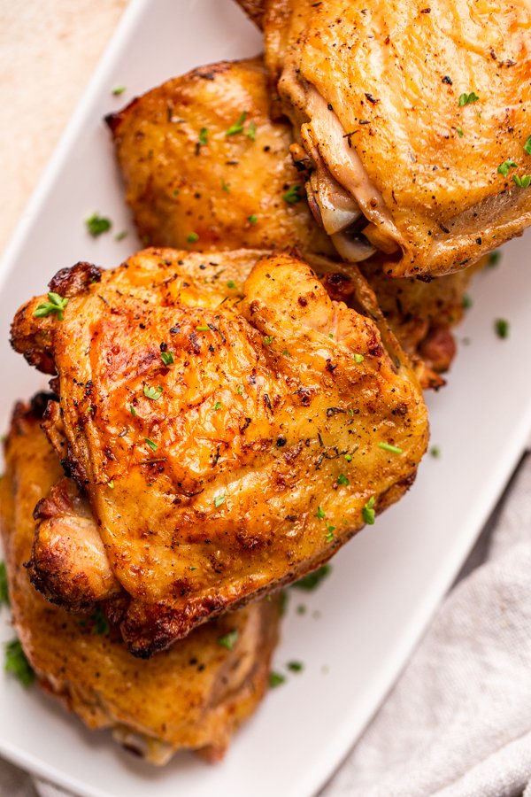 traeger grilled chicken thighs on a white rectangular plate