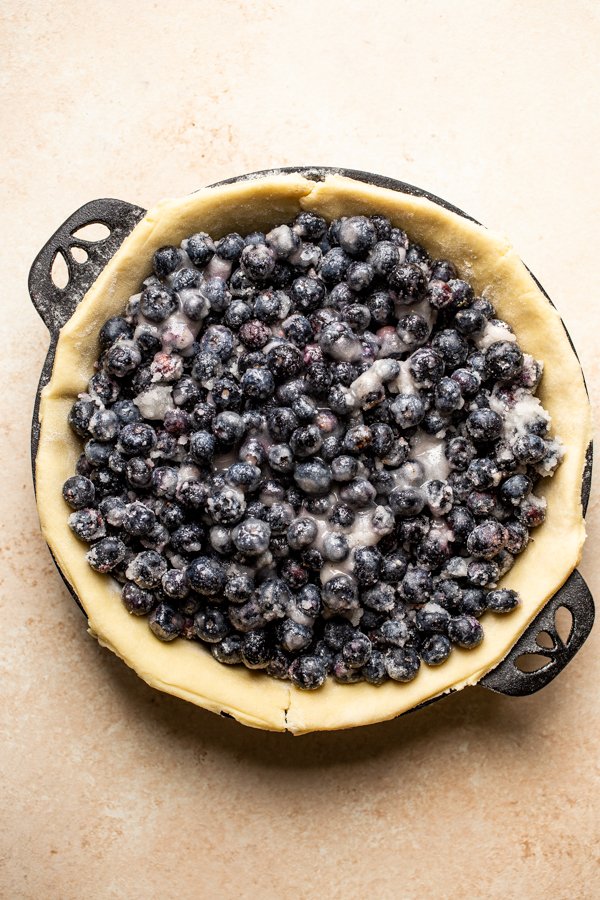 pie crust with blueberries in a cast iron pie plate