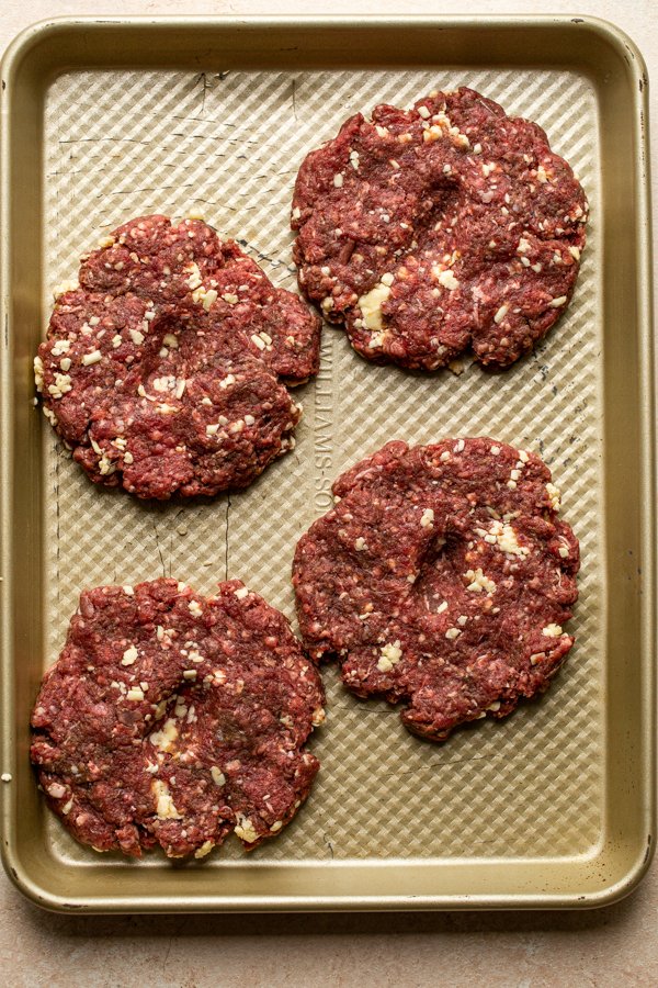 venison burger patties on a baking sheet