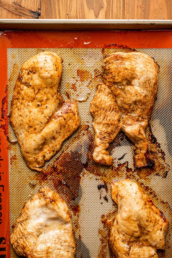 baked chicken on a baking sheet lined with a silpat