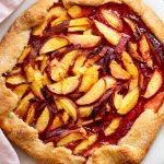 baked peach galette on a white marble server