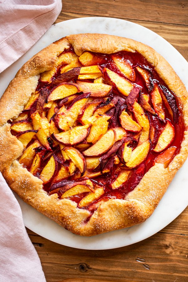 baked peach galette on a white marble server