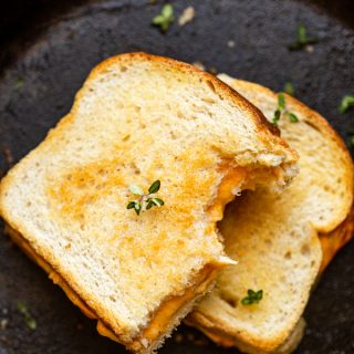 traeger grilled cheese stacked and cut in half on a skillet