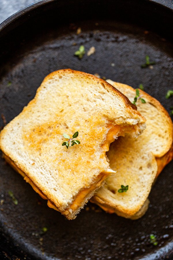 traeger grilled cheese stacked and cut in half on a skillet