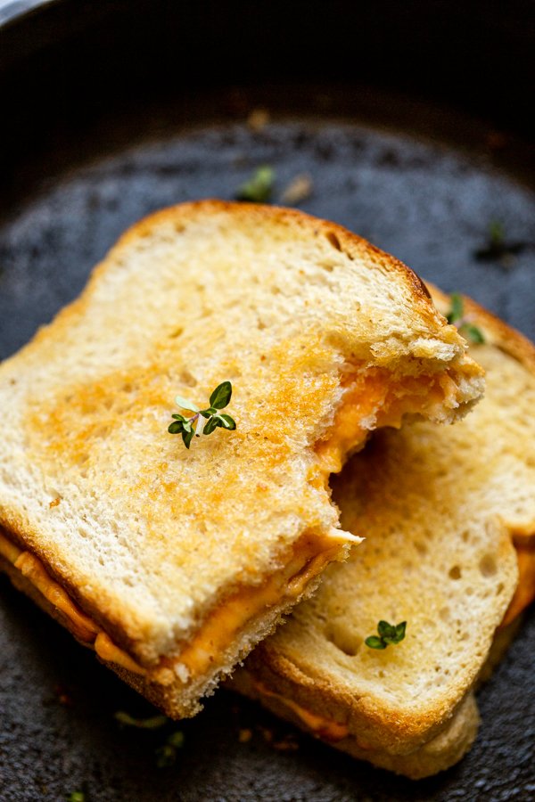 traeger grilled cheese stacked and cut in half on a skillet