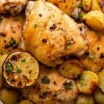 a chicken thigh roasted with potatoes and lemon