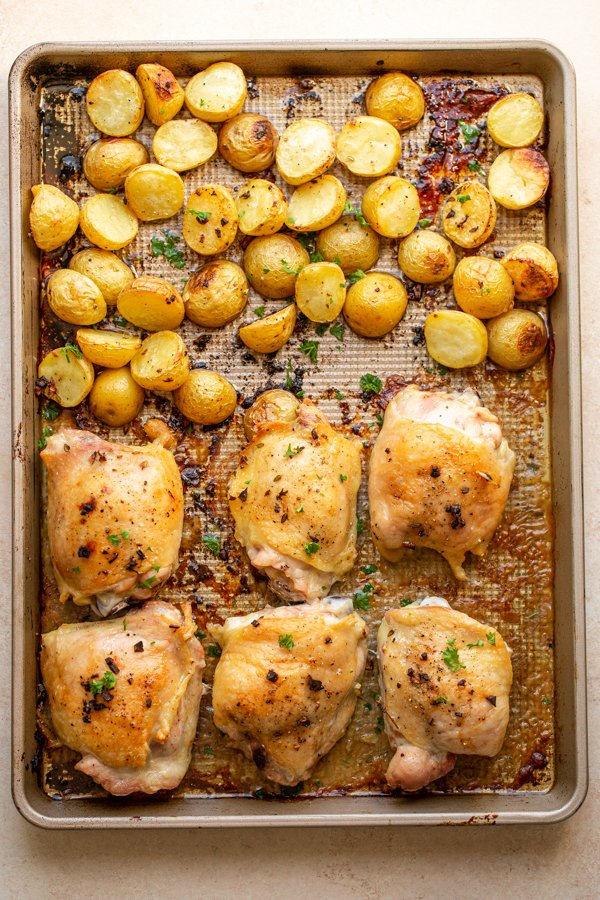 roasted chicken thighs and potatoes on a sheet pan