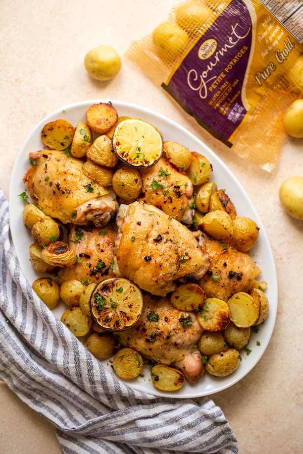 chicken and potato bake with lemons on an oval serving platter