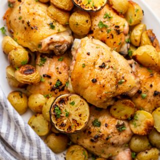 chicken and potato bake with lemons on an oval serving platter