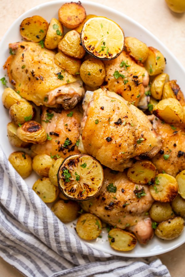 chicken and potato bake with lemons on an oval serving platter