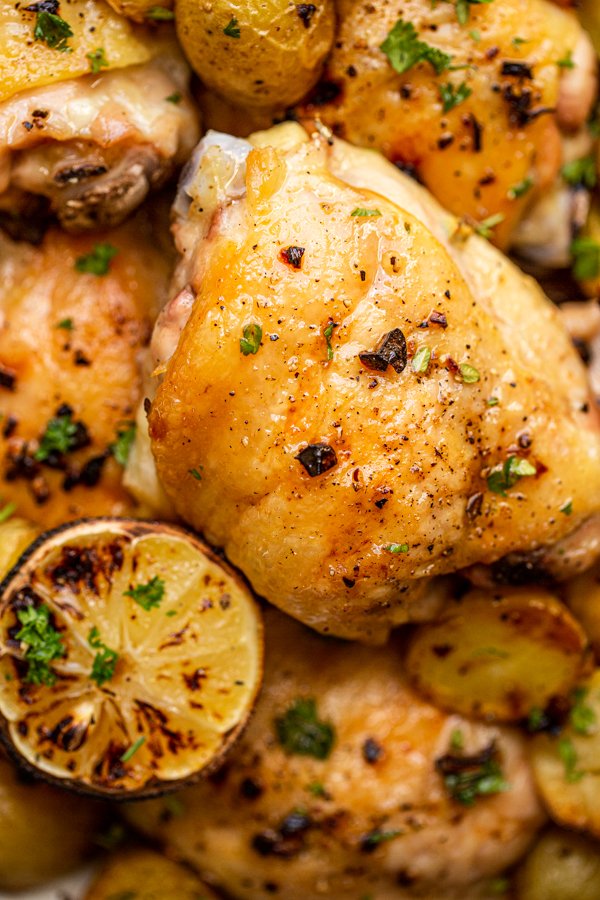 a chicken thigh roasted with potatoes and lemon