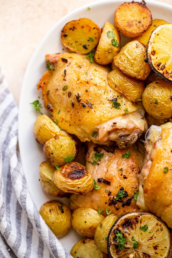 chicken and potato bake with lemons on an oval serving platter