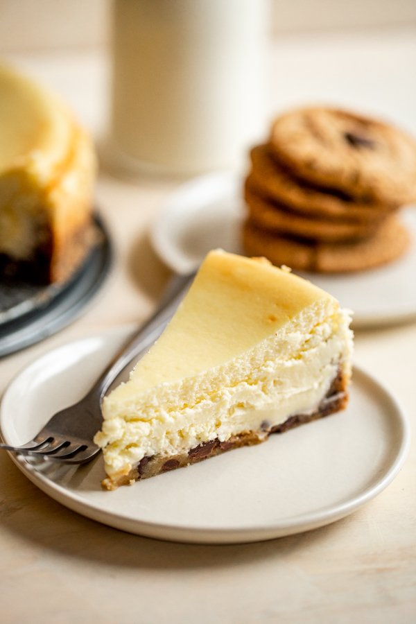 chocolate chip cookie crust cheesecake slice on a white plate