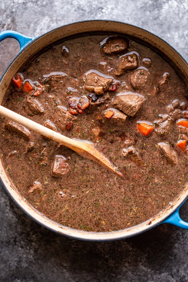 venison bourguignon in a pot before simmering