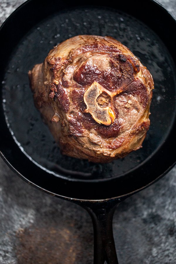 A seared venison roast in a cast iron pan. 