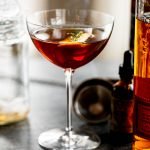 a smoked manhattan cocktail on a grey counter