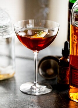 a smoked manhattan cocktail on a grey counter