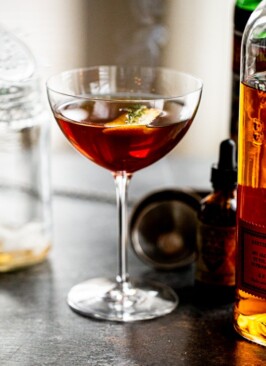 a smoked manhattan cocktail on a grey counter