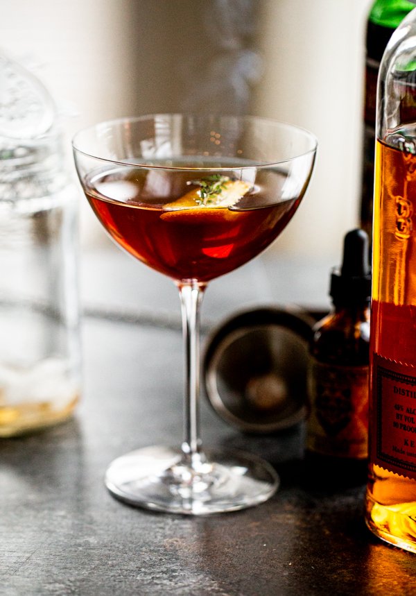 a smoked manhattan cocktail on a grey counter