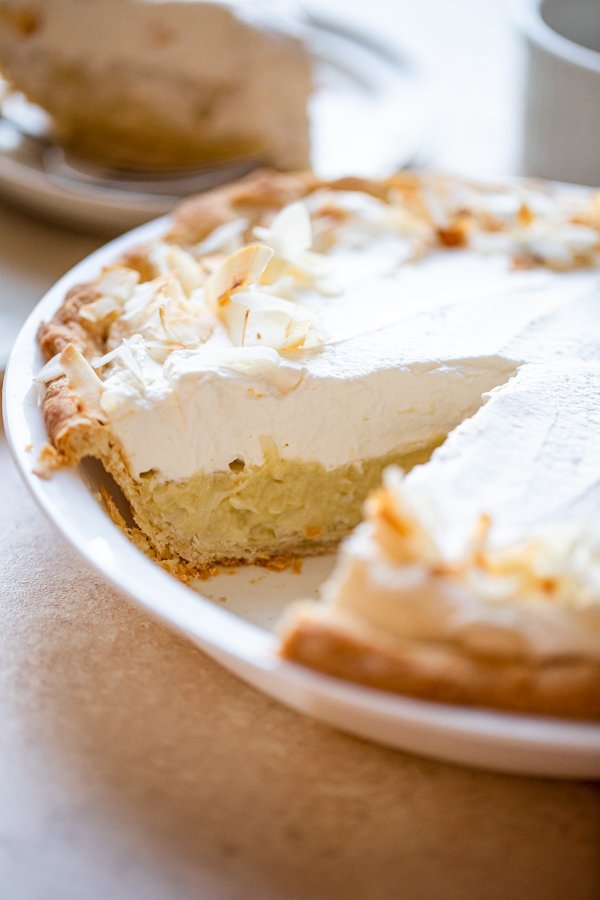 a slice cut out of a coconut cream pie