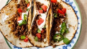 ground venison tacos on a blue and white plate